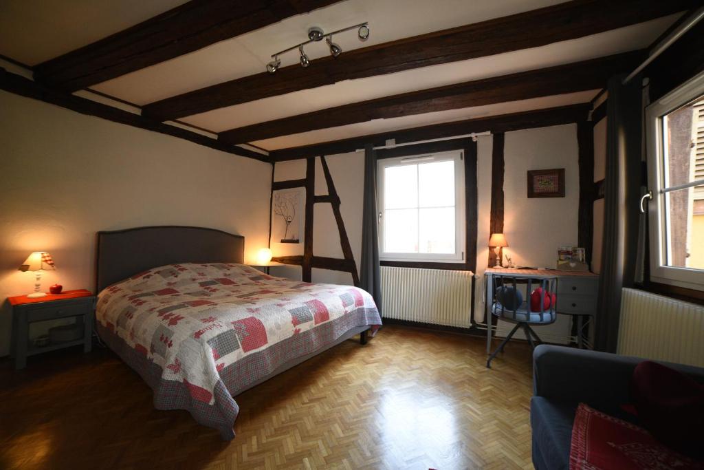 a bedroom with a large bed and a large window at Gite Bim Maidala in Colmar
