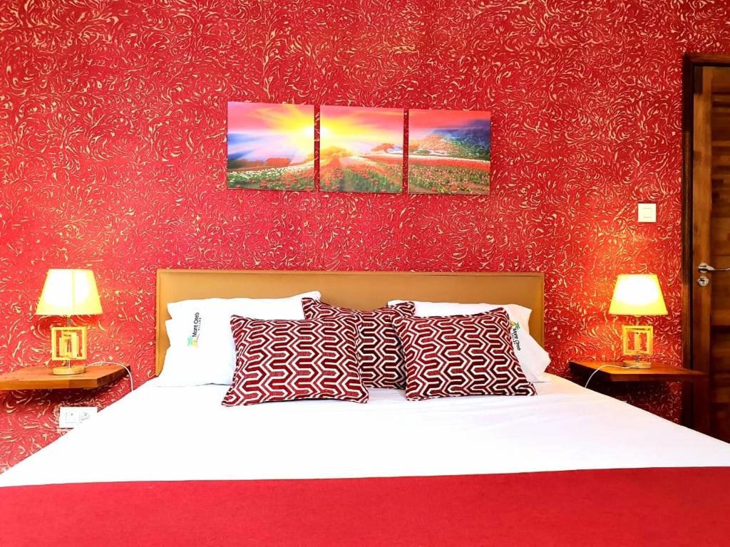 een slaapkamer met een wit bed met rode muren bij Mont Oreb Villas ( Ruby) in Grand Baie