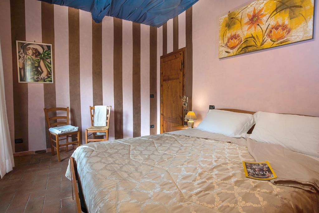 a bedroom with a bed and a striped wall at Casa di Pierina in Poggibonsi
