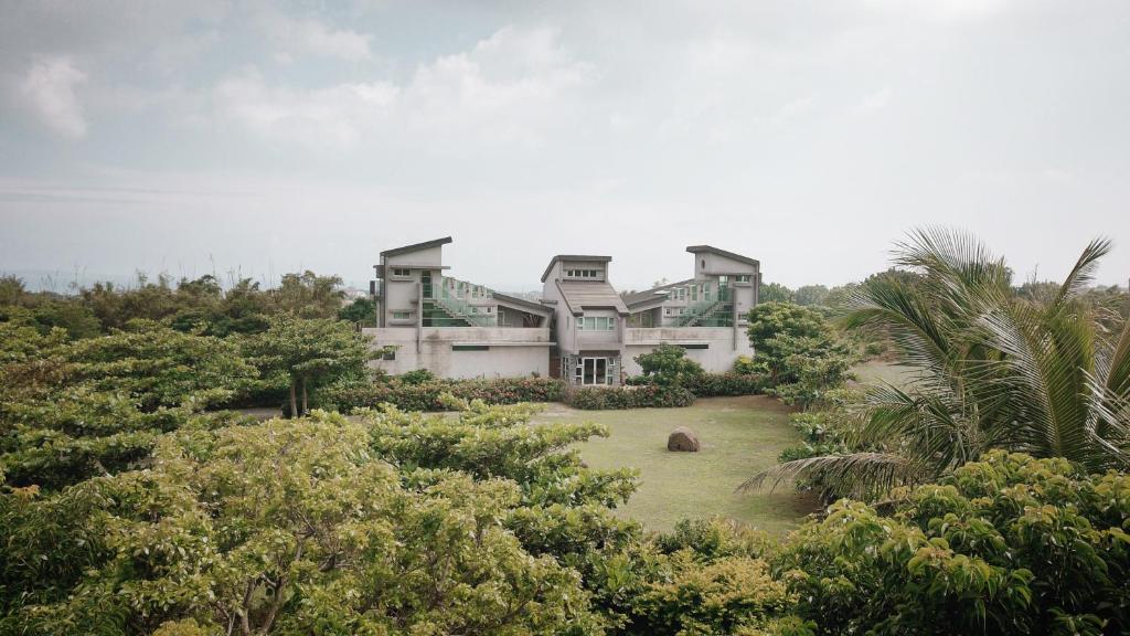a large house on top of a hill with trees at 57villa in Hengchun South Gate