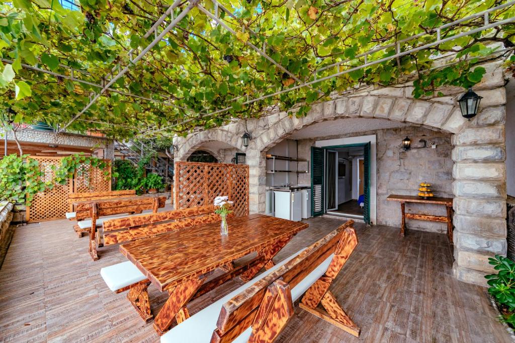 a wooden table and benches on a patio at Hotel Savojo in Petrovac na Moru
