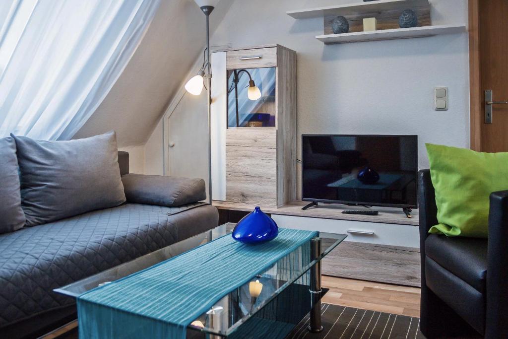 Una sala de estar con un sofá y un televisor. en Ferienwohnung Carla, en Celle