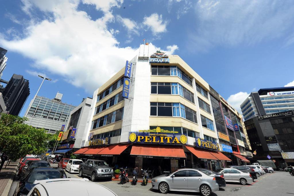 a building on a busy city street with cars parked at Palm Inn Ampang Point in Ampang