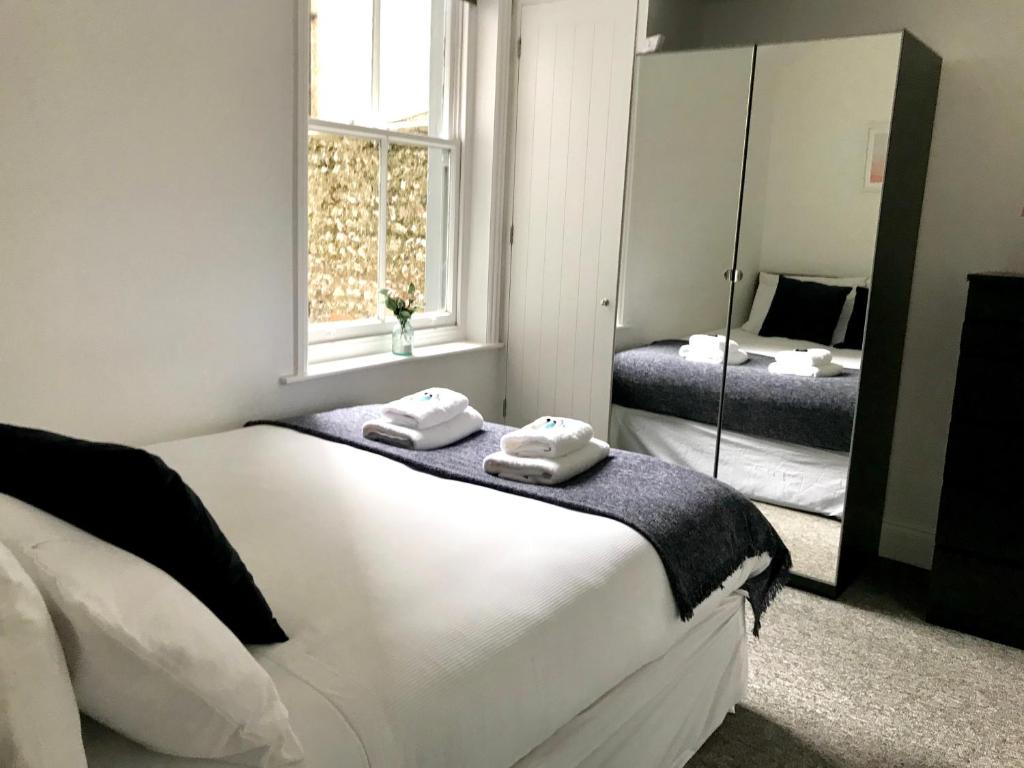een slaapkamer met een groot wit bed en een spiegel bij Brighton 2 Bed 2 Bath & Terrace in Brighton & Hove