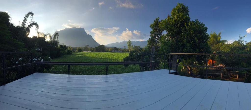 a large wooden deck with a view of a field at Dreamhome Chiangdao in Chiang Dao