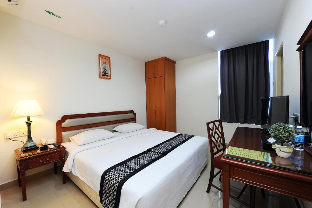 a bedroom with a bed and a desk with a computer at Palm Inn Ampang Point in Ampang