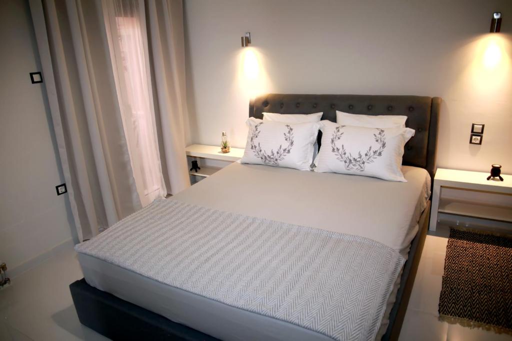 a bedroom with a bed with white sheets and pillows at Hope home in Volos