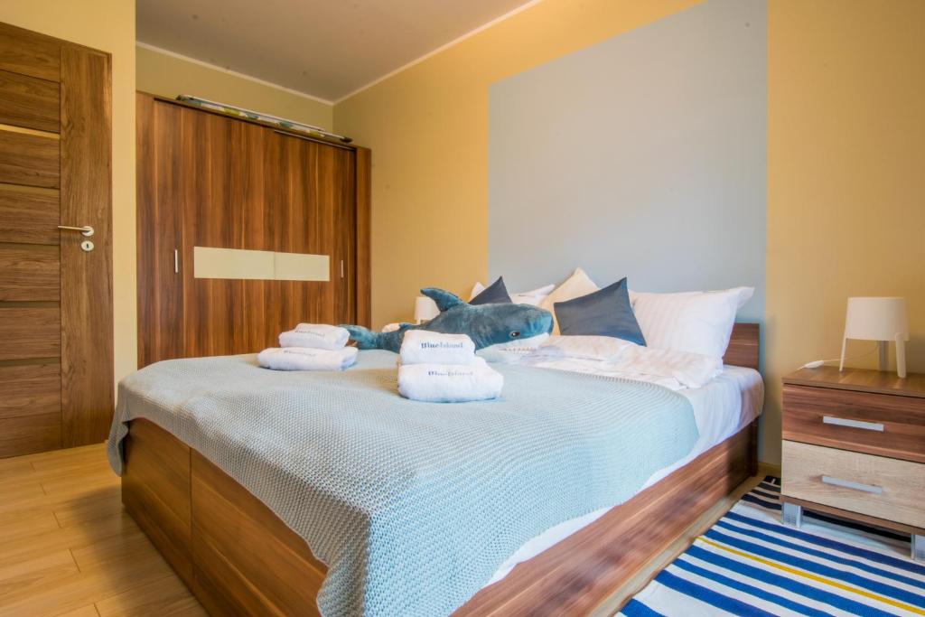 a bedroom with a bed with towels on it at Apartament Blue Island in Kołobrzeg