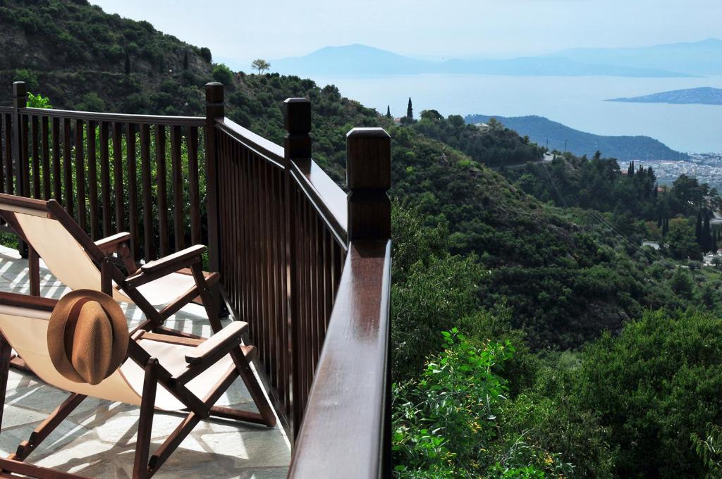 a deck with a chair and a hat on it at BLUE GREY cottage in Portaria