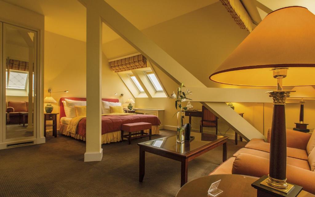 a hotel room with a bed and a couch and a lamp at Le Palais Art Hotel Prague in Prague