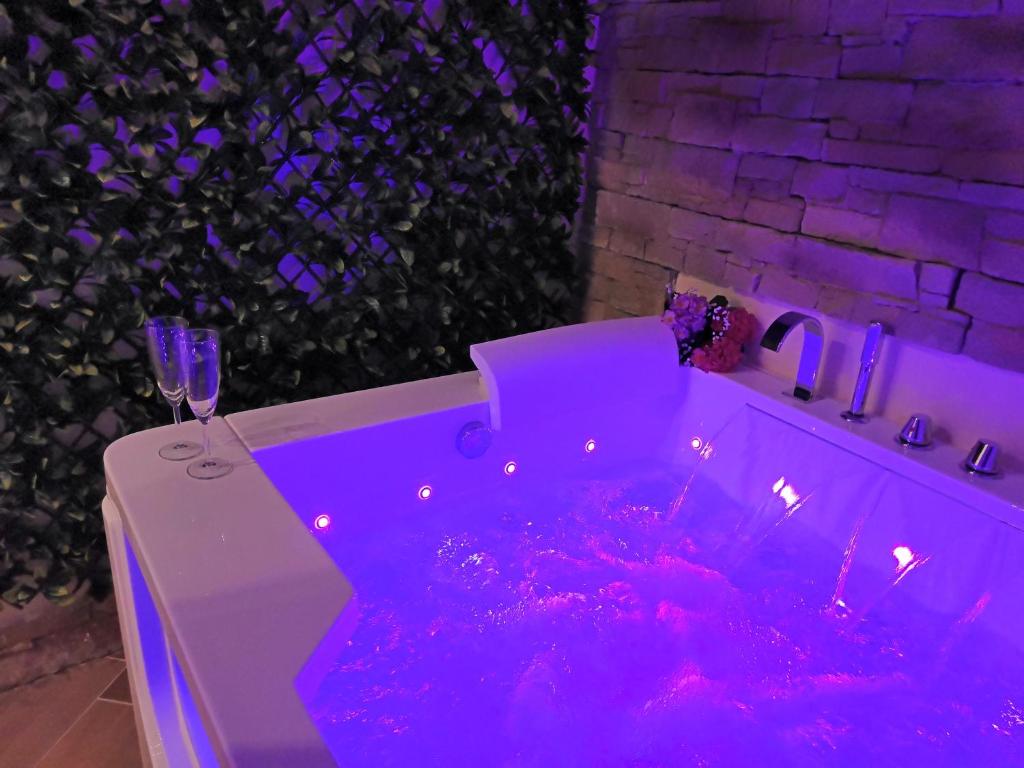 a purple bathtub with a glass of wine and a wine glass at Historia Vitiello: The First Experience Suite in Santa Margherita Ligure