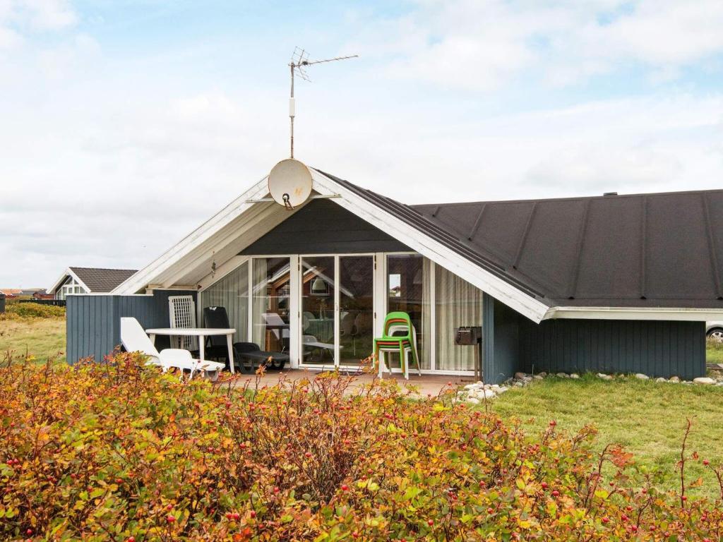 a house with a black roof with a patio at 5 person holiday home in Harbo re in Harboør