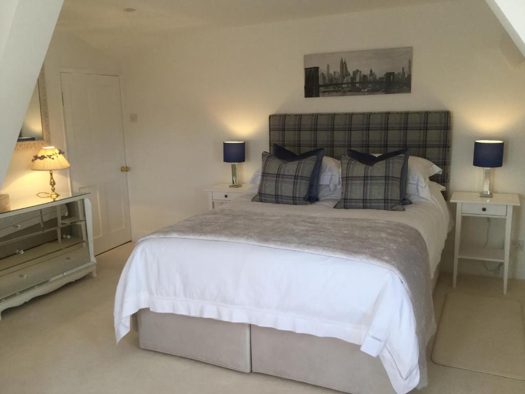 a bedroom with a large white bed with two lamps at Park House in Budleigh Salterton