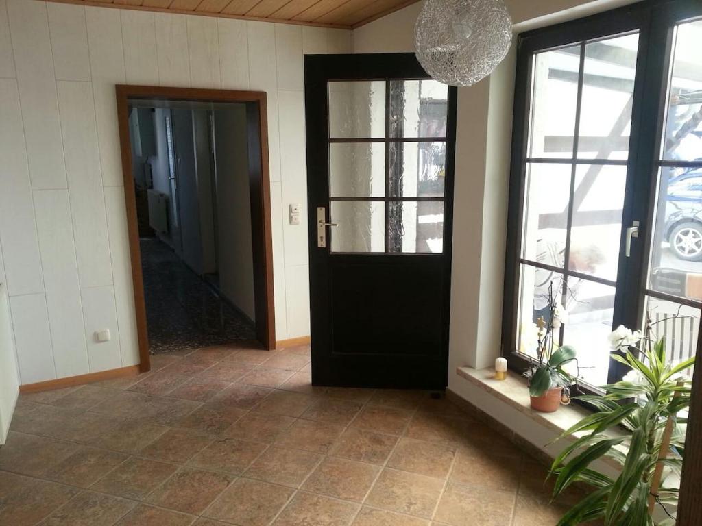 a hallway with a black door and windows at KLEIN - Ferienhaus Thüringen Erfurt Apfelstädt Drei Gleichen in Apfelstädt