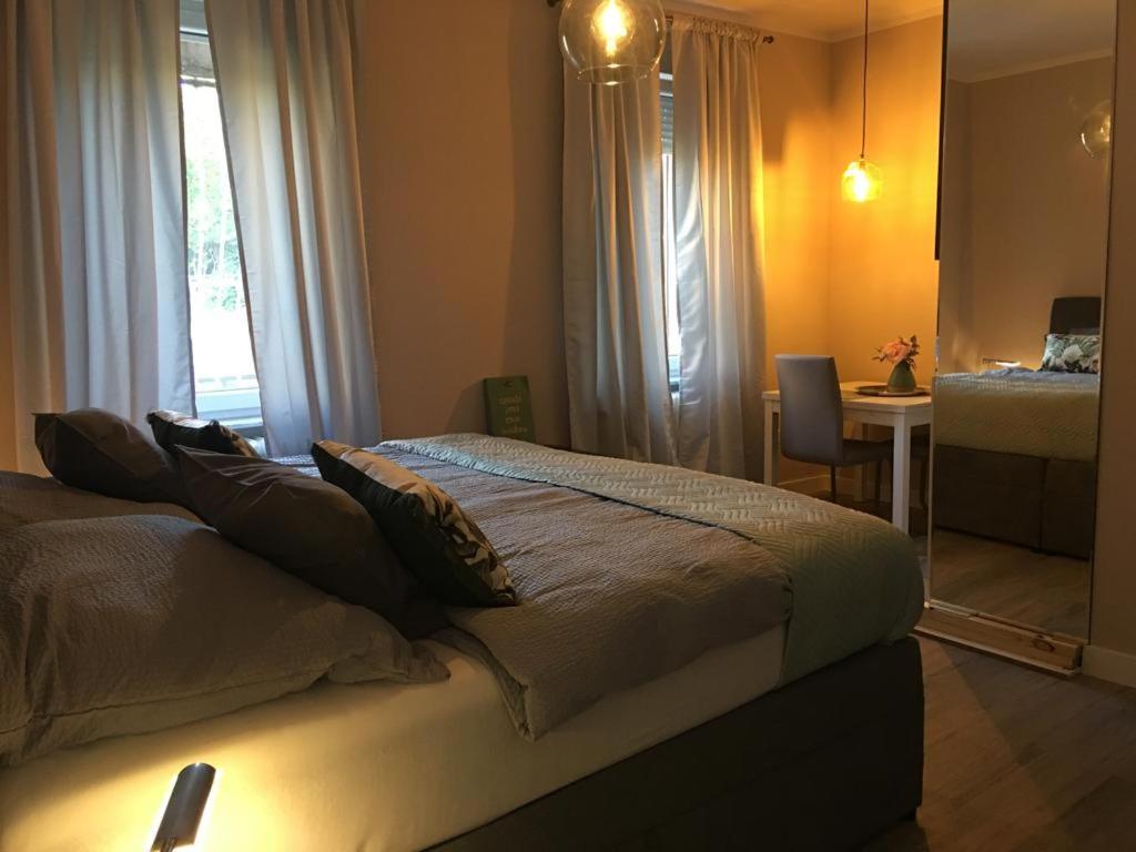a bedroom with a bed and a desk and a mirror at Villa Rosa Bad Camberg in Bad Camberg