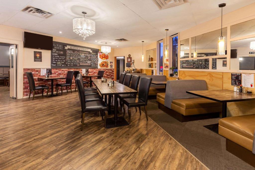 a restaurant with tables and chairs and a bar at Ramada by Wyndham Coquitlam in Coquitlam