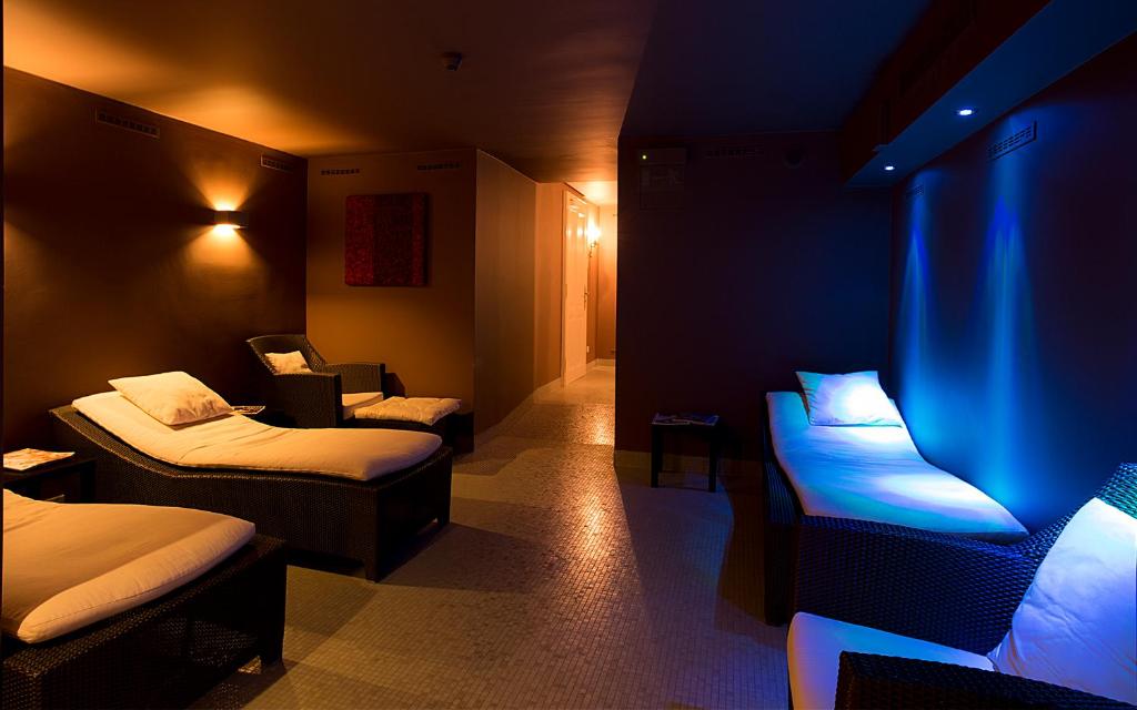 a room with two beds and a blue light at Le Palais Art Hotel Prague in Prague