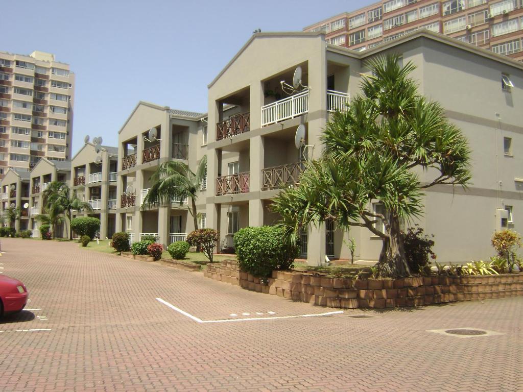 a row of apartment buildings on a brick street at North Beach Durban Apartments in Durban