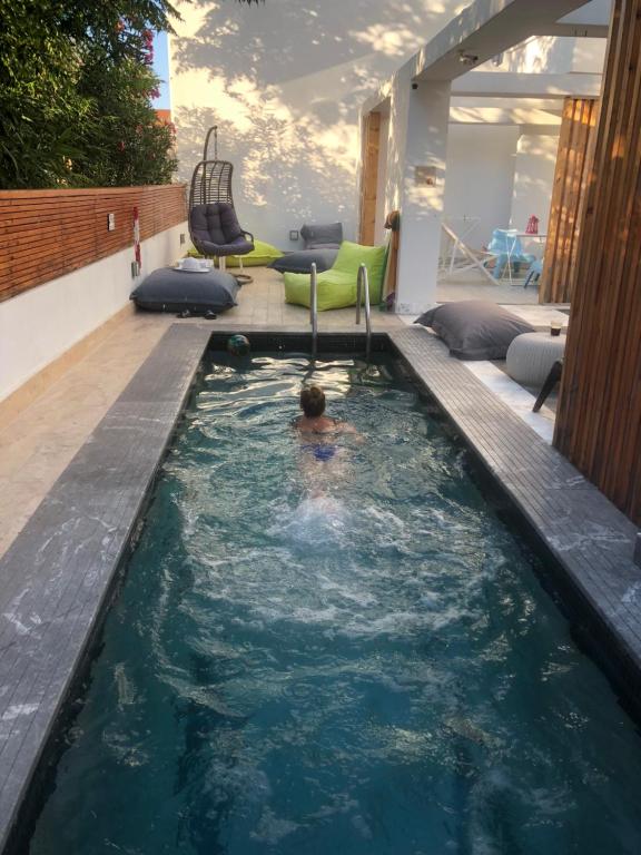 un hombre en una piscina en una casa en Atlas Relax, en Kallithea Halkidikis