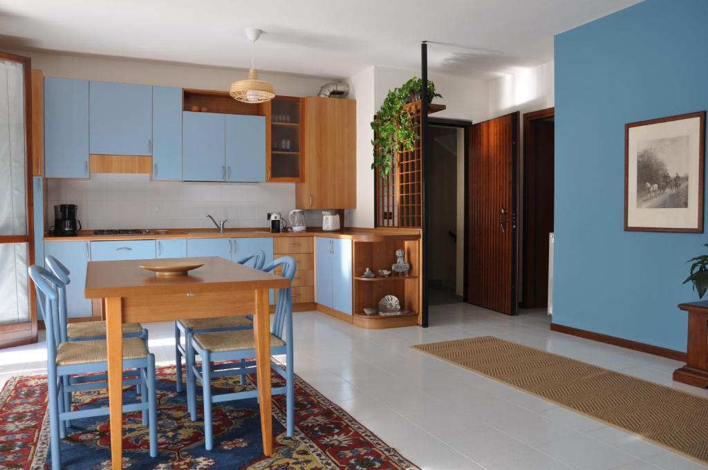 une cuisine avec une table en bois et des chaises bleues dans l'établissement Casa Marisa, à Lovere