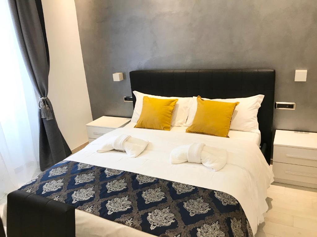 a bedroom with a large bed with yellow pillows at Rose Suite in Rome