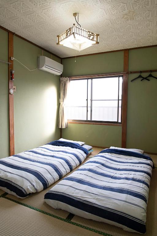 Postel nebo postele na pokoji v ubytování TSUKASA HOUSE English OK Kumano Kodo Experienced Lodge Within walking distance from station 無料駐車場あり