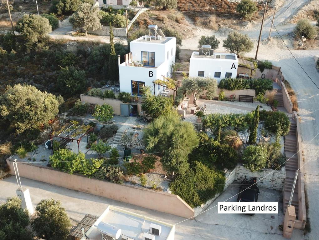 une vue aérienne sur une maison avec un parking dans l'établissement Landros, à Kamilárion