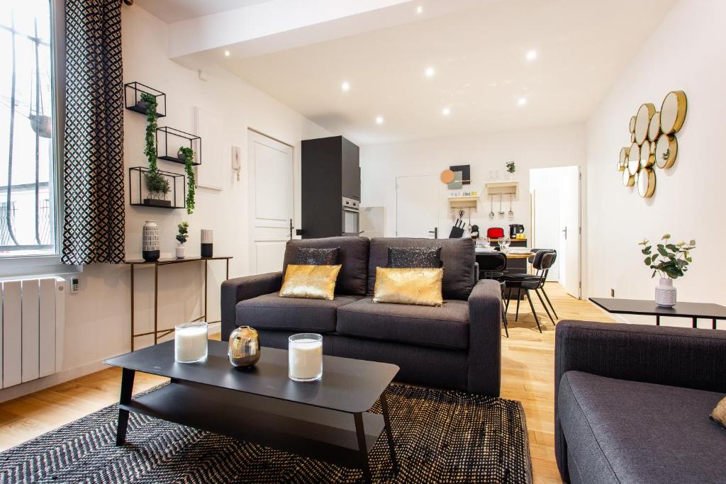 a living room with a couch and a table at CMG Montmartre/ Marché Saint-Pierre in Paris