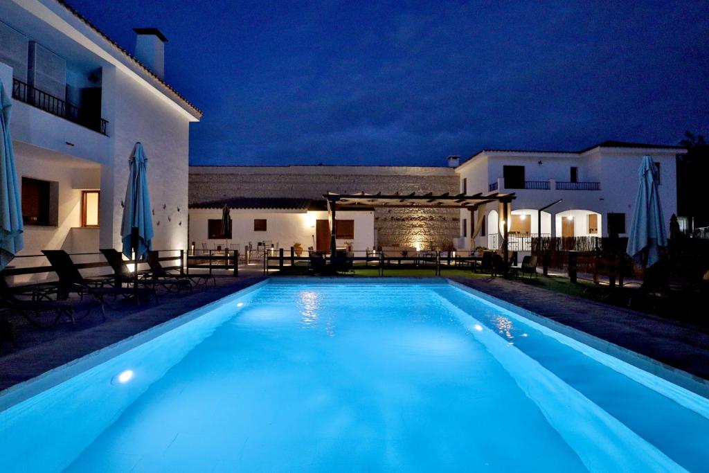 - une piscine en face d'un bâtiment la nuit dans l'établissement Hacienda El Brillante, à Cordoue