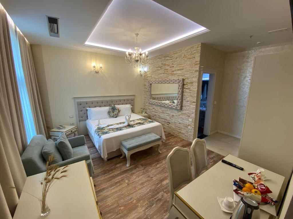 ein Schlafzimmer mit einem Bett und ein Wohnzimmer in der Unterkunft The Red Bricks Hotel in Shkodra