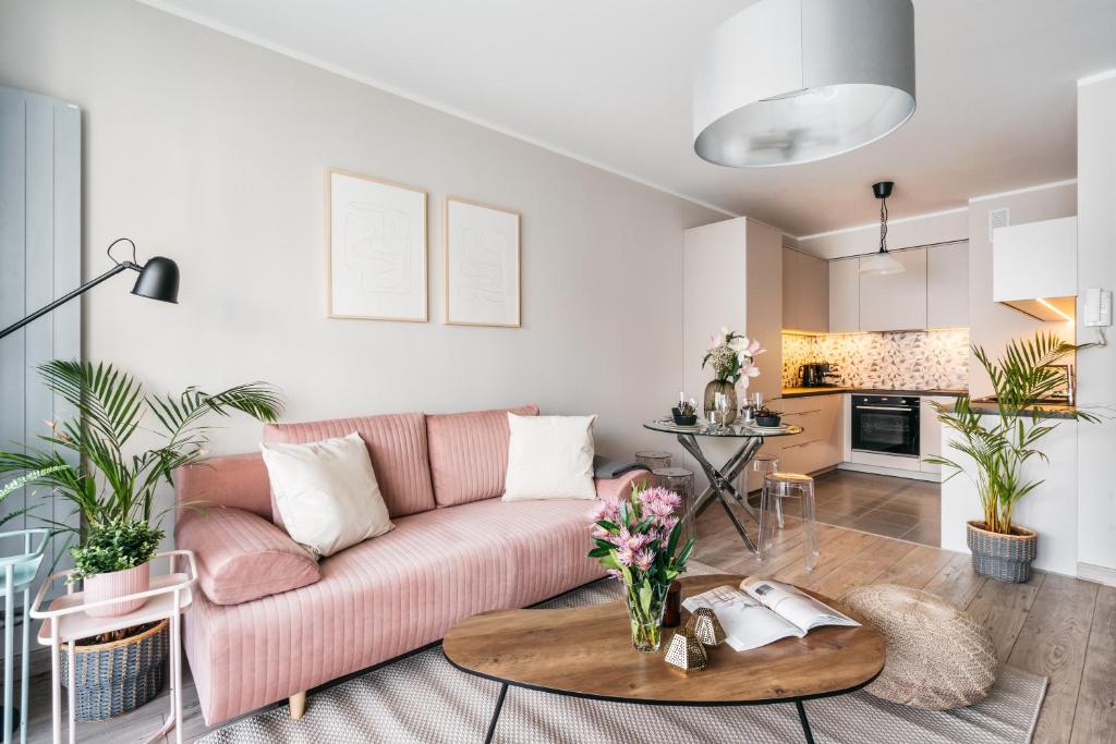 a living room with a pink couch and a table at Garden Apartments by LoftAffair in Krakow