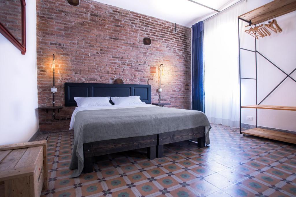 カッラーラにあるCarrara Bellaのレンガの壁、ベッド付きのベッドルーム1室