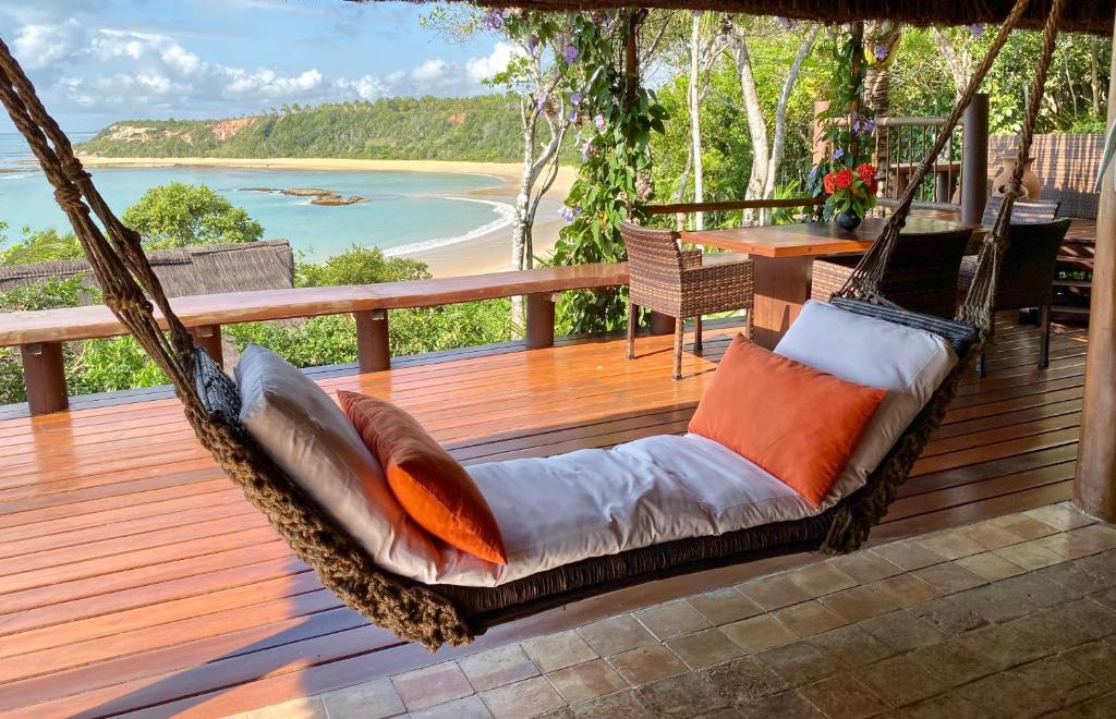 a swing on a deck with a view of the ocean at Bahia Beach House in Praia do Espelho