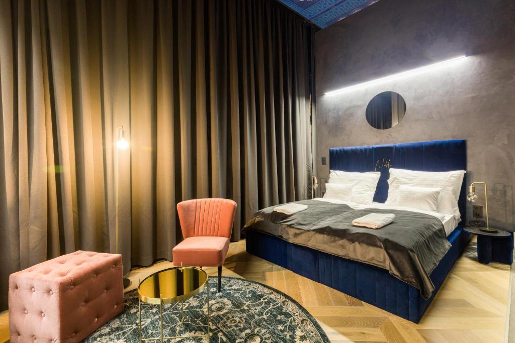 um quarto com uma cama, uma cadeira e uma mesa em Noble Boutique Hotel - Adults Only em Budapeste