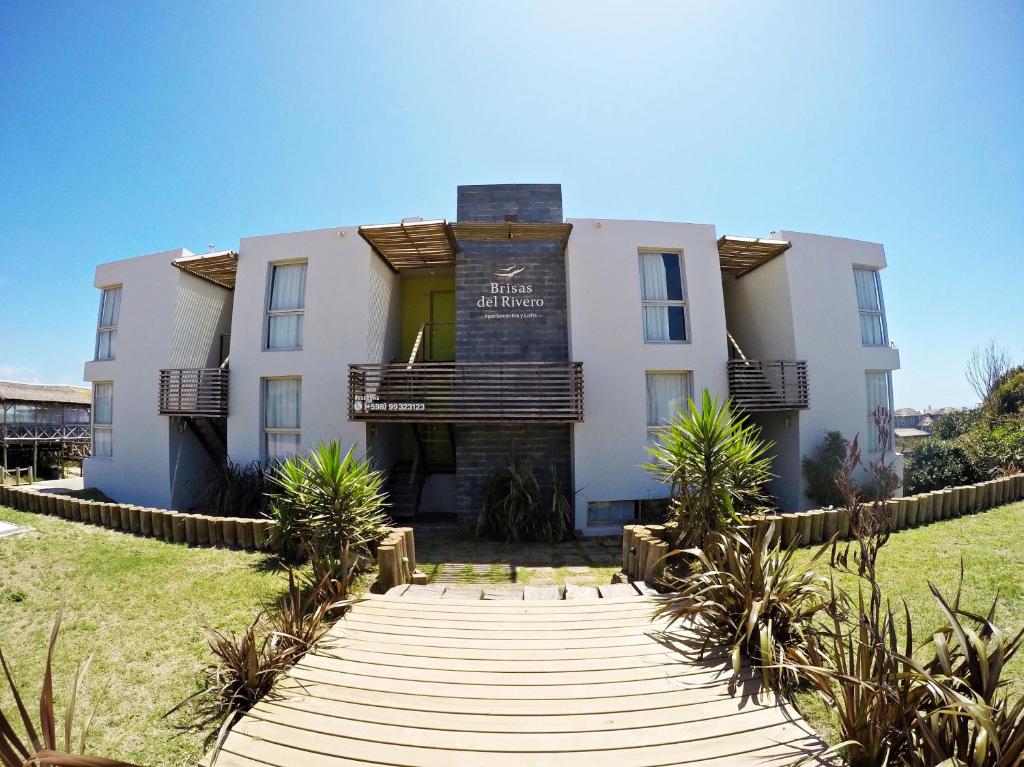 a building with a boardwalk in front of it at Brisas del Rivero in Punta Del Diablo