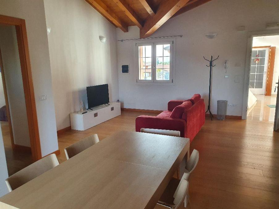- un salon avec une table et un canapé rouge dans l'établissement Happy house villotta, à Chions