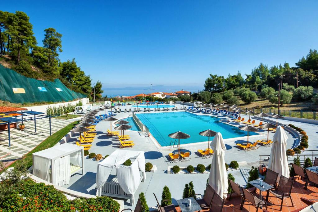 佩科霍里的住宿－中庭酒店，享有带椅子和遮阳伞的游泳池的上方景致