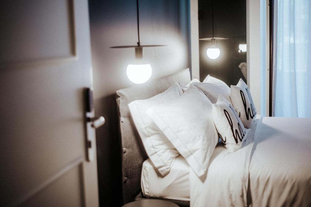 una camera da letto con un letto con cuscini bianchi di Cà Bèla - Porta Romana a Milano