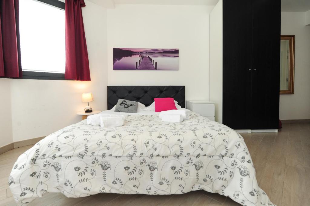 - une chambre avec un grand lit blanc et un oreiller rose dans l'établissement Les Oranges Five Stars HolidayHouse, à Nice