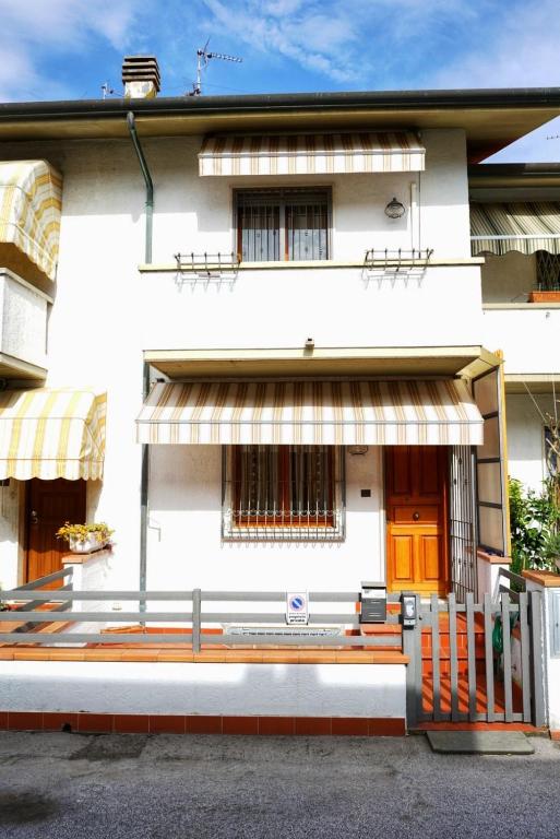 a white house with a fence in front of it at Casa Ceragioli in Viareggio