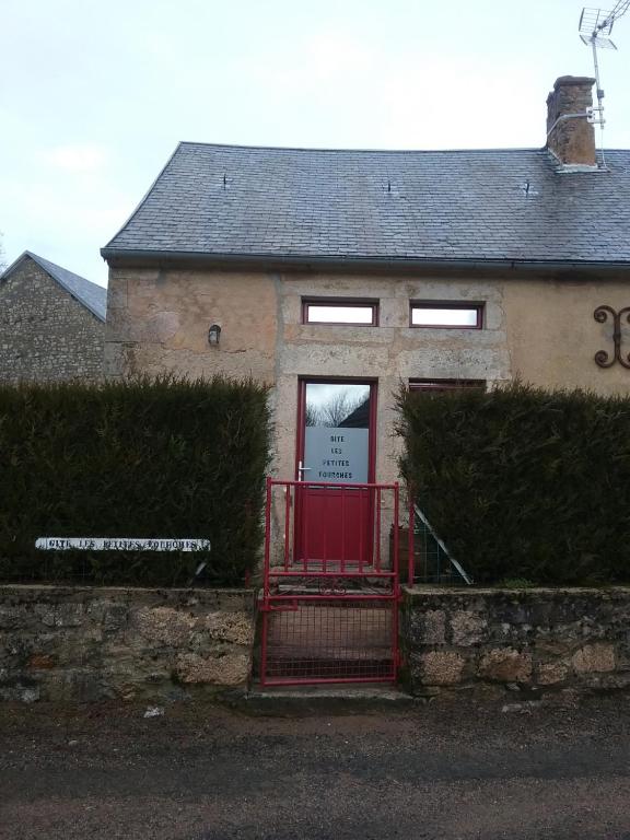 a house with a red gate in front of it at Les petites Fourches in Saint-Brisson