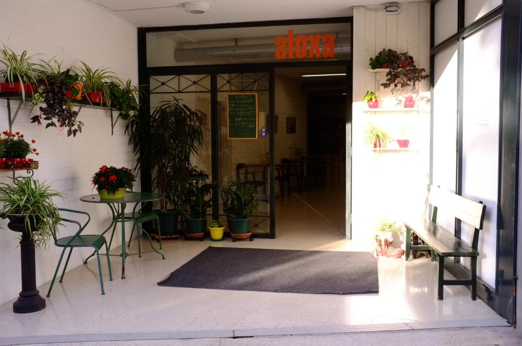 uma entrada para um edifício com uma mesa e cadeiras em ALBERGUE ALOXA HOSTEL em Pontevedra