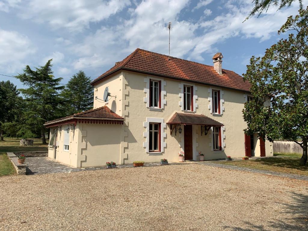 una gran casa blanca con una entrada delante de ella en Le Pontet, en Miramont-de-Guyenne