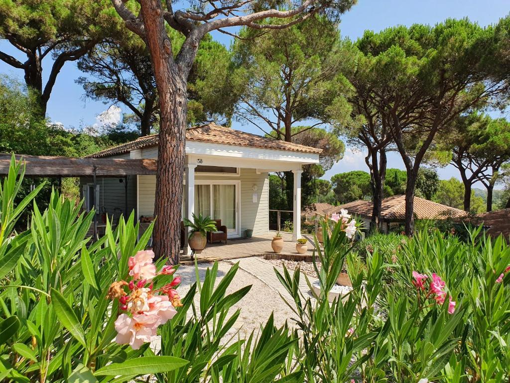 uma pequena casa branca com árvores e flores em Saint tropez -parc oasis em Gassin