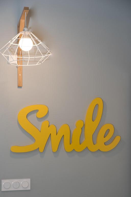 a lamp and the word smile hanging on a wall at L'Olivaroise in Toulon