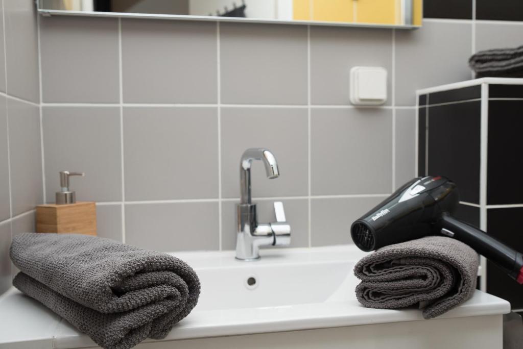 a blow dryer sitting on a bathroom sink with towels at L'Olivaroise in Toulon