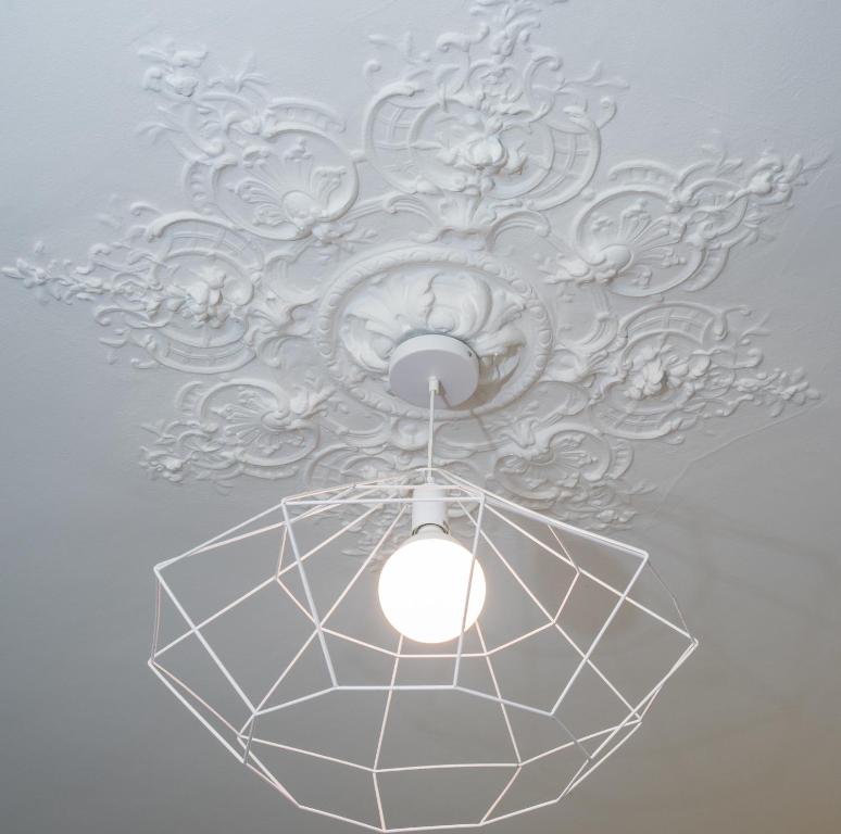 a ceiling light with a white chandelier on a ceiling at L'Olivaroise in Toulon