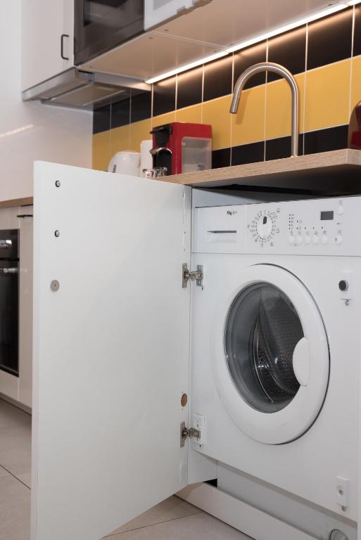 a washing machine in a kitchen with a sink at L'Olivaroise in Toulon