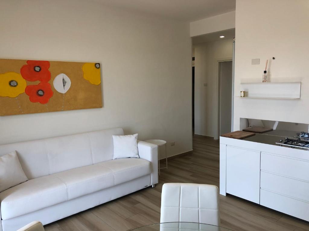a living room with a white couch and a kitchen at LOFT12 - Luxury Apt. in Santa Maria Capua Vetere