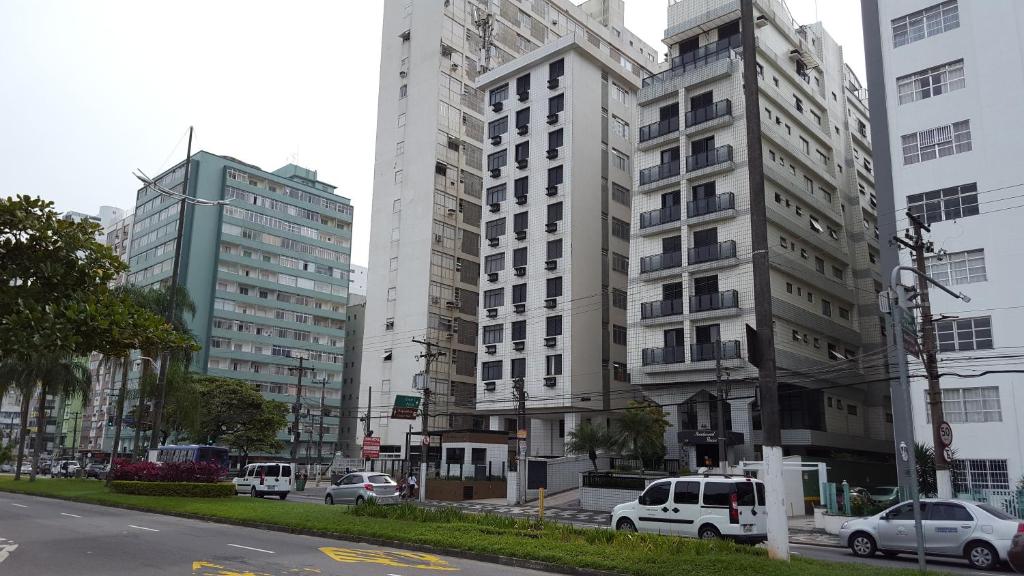 twee hoge gebouwen in een stadsstraat met auto's bij Santos Apartamento Frente Mar - Ar Condicionado na Suíte - Garagem Privativa -Internet - TV a Cabo in Santos